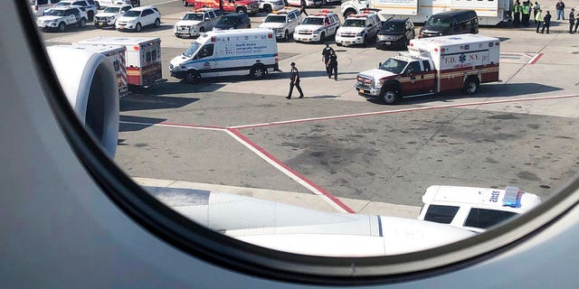Emergency response crews gather outside a plane at New York's Kennedy Airport amid reports of ill passengers aboard a flight from Dubai on Wednesday.