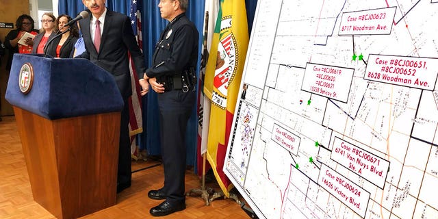 Los Angeles City Attorney Mike Feuer, at podium, and police Chief Michel Moore announce that prosecutors have charged more than 500 people with misdemeanors for illegal marijuana operations, at a news conference in Los Angeles, Sept. 7, 2018.