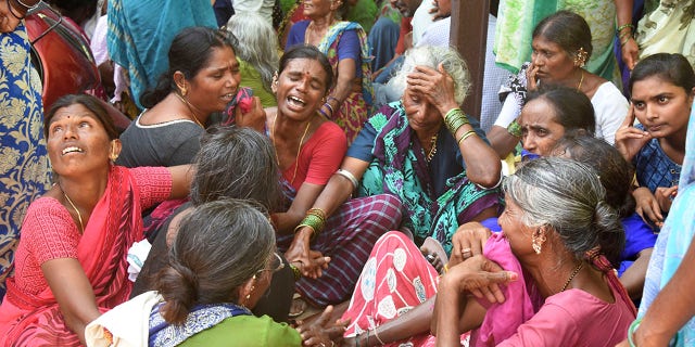 Relatives of victims of a bus accident wail near a hospital in Jagtiyal district of Telangana, India.