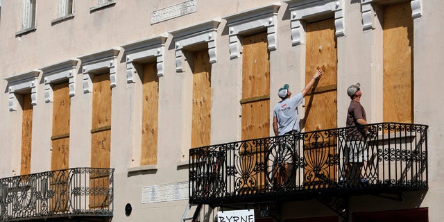 Derek Mundy, left, and Kris Crouse boards up the Confederate House in preparation for Hurricane Florence in downtown Charleston, S.C.