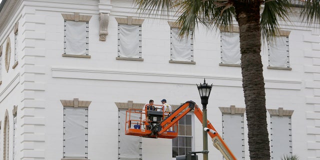 Workers cover the windows of the historic Charleston County Courthouse in Charleston, S.C., in preparation for the advancing Hurricane Florence.