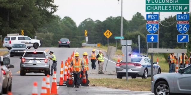 South Carolina state troopers work with D.O.T. employees at an access ramp to I-26 in Columbia, South Carolina.