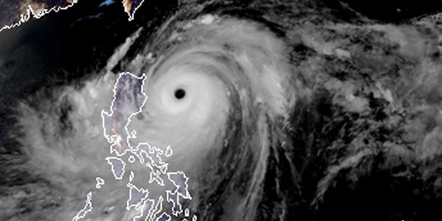 a satellite image with land graphic borders shows the width and trajectory of Typhoon Mangkhut as it approaches the Philippines.