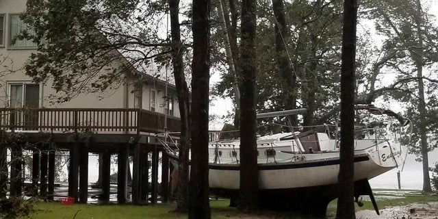 This photo provided by Angie Propst, shows a boat wedged in trees during Hurricane Florence in Oriental, North Carolina.