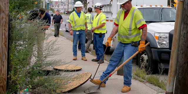 FILE: A worker with Columbia Gas pries the manhole cover open as they work to make sure there are no gas leaks at the corner of Parker and Salem Streets in Lawrence, Mass.