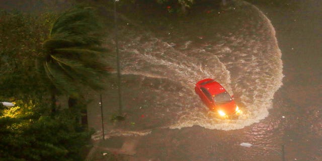 A vehicle swerves through a flooded street in Manila after Typhoon Mangkhut wreaked havoc in the area.