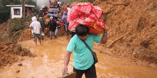 Families and relatives of miners in Itogon township, Benguet province in the northern Philippines, carry their belongings as they evacuate following landslides which were triggered by Typhoon Mangkhut burying an unknown number of miners and isolating the township.