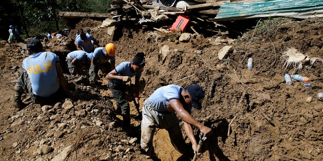 Rescuers push water along a drainage as operations continue at the site where victims are believed to have been buried by a landslide after Typhoon Mangkhut lashed Itogon, Benguet province.