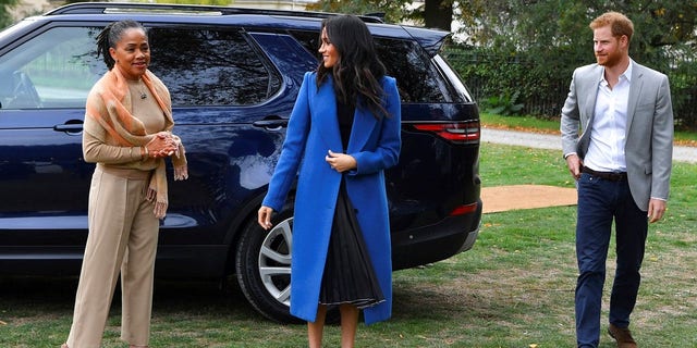Meghan, the Duchess of Sussex, accompanied by Britain's Prince Harry, the Duke of Sussex and her mother Doria Ragland walk to attend a reception at Kensington Palace.