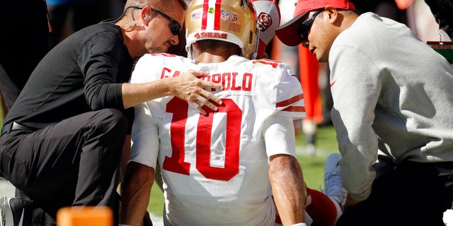 FILE: Trainers attend to San Francisco 49ers quarterback Jimmy Garoppolo (10) who was injured after a tackle by Kansas City Chiefs defensive back during the second half of a game in Kansas City, MO.