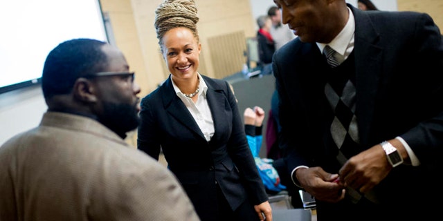 FILE- In this Friday, Jan. 16, 2015 file photo, Rachel Dolezal, Spokane's newly elected NAACP President, smiles as she meets with Joseph M. King of King's Consulting, left, and Dr. Scott Finnie, director and senior professor of EWU's Africana Education Program before the start of a Black Lives Matter Teach-In on Public Safety and Criminal Justice at EWU in Cheney, Wash. (Tyler Tjomsland/The Spokesman-Review via AP, File) COEUR D'ALENE PRESS OUT