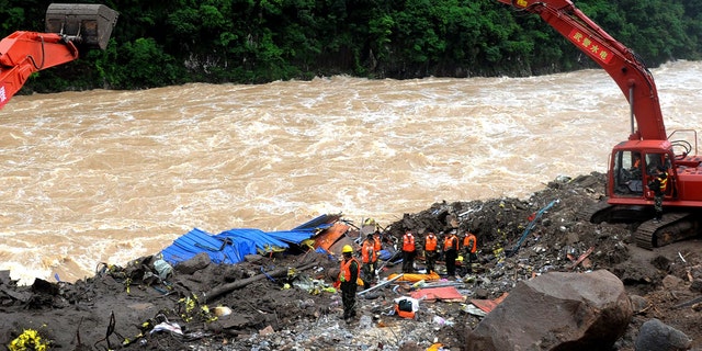 Rescuers pay respects to the body of a landslide victim in southeast China's Fujian province Monday.