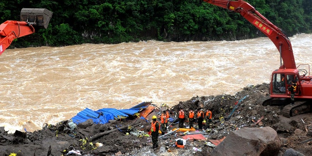 Rescuers pay respects to the body of a landslide victim in southeast China's Fujian province Monday.
