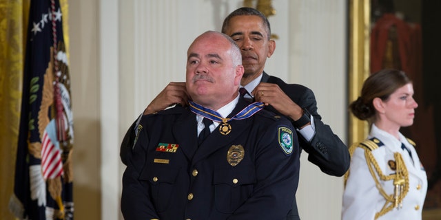 President Barack Obama presents the Medal of Valor to Midwest City, Okla. Police Major David Huff.