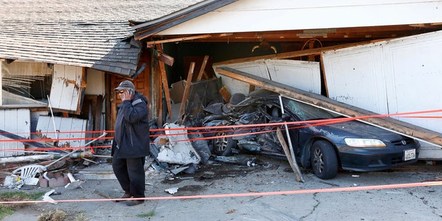 Ray Minter talks on the phone after a truck ran into his home near Interstate 680 in San Jose Tuesday.