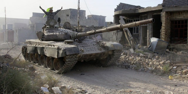 Iraqi security forces advance their positions during heavy fighting against Islamic State group militants in Fallujah on Tuesday.