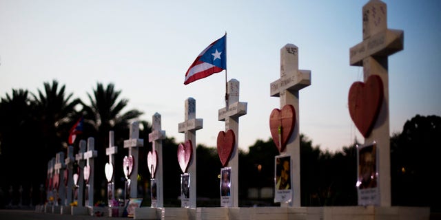 Crosses, one for each victim, line a walkway as a memorial to those killed in the Pulse nightclub mass shooting a few blocks from the club early Friday, June 17, 2016, in Orlando, Fla. (AP Photo/David Goldman)