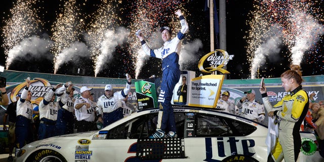 Brad Keselowski stands on his car in Victory Lane after his win in the NASCAR Sprint Cup Series auto race at Kentucky Speedway, Saturday, July 9, 2016 in Sparta, Ky. (AP Photo/Timothy D. Easley)