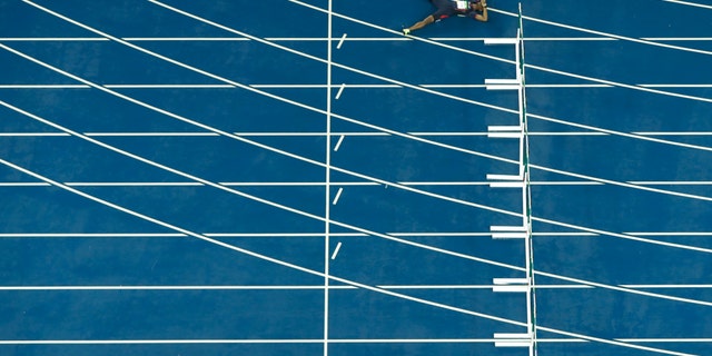 France's Wilhem Belocian lays on the track after his false start in a 110 meter hurdles heat during the athletics competitions of the 2016 Summer Olympics at the Olympic stadium in Rio de Janeiro, Brazil, Monday, Aug. 15, 2016. (AP Photo/Morry Gash)