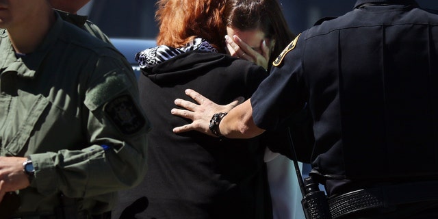 Two women grieve after hearing news of the shooting at Heritage Court Apartments Wednesday.
