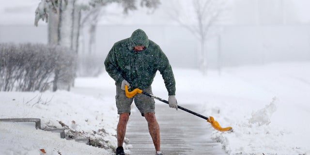 Peter Lidstone shovels his sidewalk in St. Cloud, Minn.