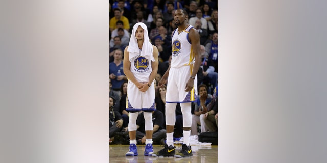 The Golden State Warriors' Stephen Curry, left, and Kevin Durant watch during the second half of Thursday's game.