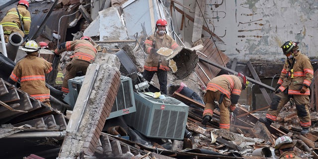 Emergency crews clear debris at the scene of the building collapse in Sioux Falls.