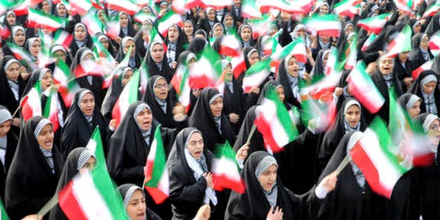 Iranian school girls wave national flags during the annual rally in Tehran.