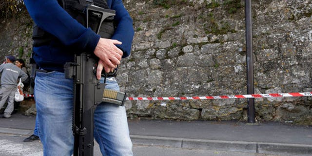 A police officer secures the area outside the Alexis de Toqueville high school.