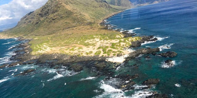 In this Friday, Aug. 18, 2017, photo provided by the U.S. Coast Guard, an MH-65 helicopter crew from Coast Guard Air Station Barbers Point passes Ka'ena Point in Hawaii.