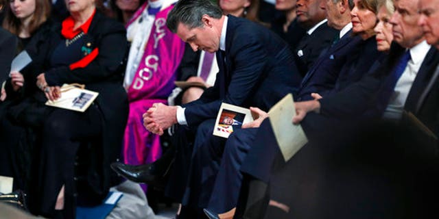California Lt. Gov. Gavin Newsom, center, reacting during the service celebrating the life of Mayor Ed Lee at San Francisco City Hall.