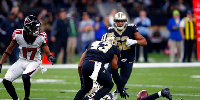 New Orleans Saints free safety Marcus Williams (43) scoops up an interception as the ball lands on the back of cornerback Marshon Lattimore.