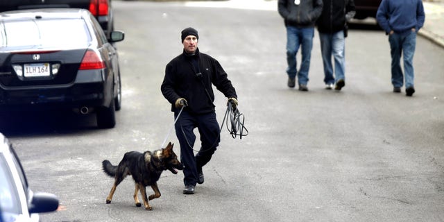 A law enforcement officer walks near the scene where a Boston police officer was shot Friday morning.