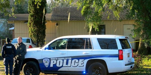 Officers stand outside a house in North Charleston, S.C., on Friday, Feb. 26, 2016, where police say a man died of an apparently self-inflicted gunshot wound after wounding a Berkeley County Sheriff's Deputy earlier in nearby Goose Creek, S.C. Police say the deputy was in serious condition at a hospital after undergoing surgery. (AP Photo/Bruce Smith)
