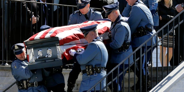 Pallbearers carry Clardy's casket out of Saint Michael Church as his widow, Reisa, far right, follows.