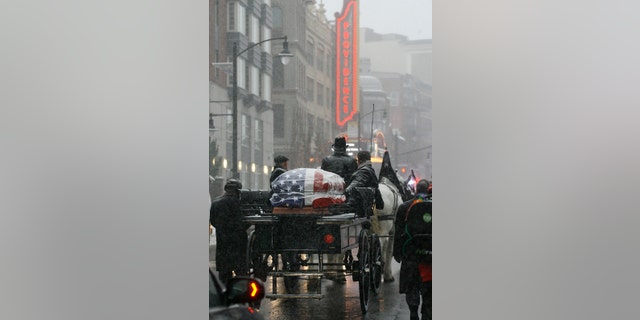 The casket of former Providence Mayor Buddy Cianci passes the Providence Performing Arts Center on a horse drawn carriage on its way to the Cathedral of Saints Peter and Paul, Monday, Feb. 8, 2016, in Providence, R.I. Cianci died Jan. 28 at age 74. He was the city's longest-serving mayor.  (AP Photo/Stew Milne)