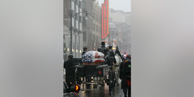 The casket of former Providence Mayor Buddy Cianci passes the Providence Performing Arts Center on a horse drawn carriage on its way to the Cathedral of Saints Peter and Paul, Monday, Feb. 8, 2016, in Providence, R.I. Cianci died Jan. 28 at age 74. He was the city's longest-serving mayor. (AP Photo/Stew Milne)