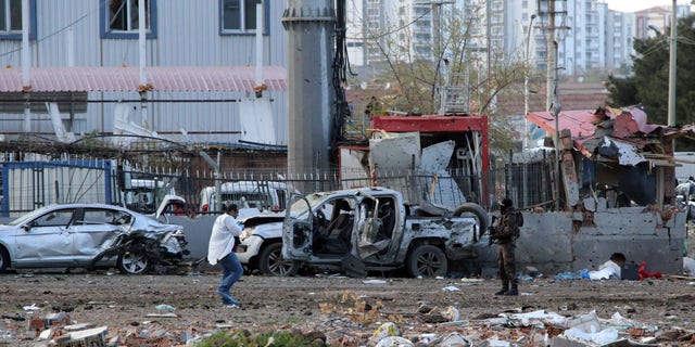 Security and forensic officials work at the site after an explosion caused by a bomb-laden car targeting police in the mainly Kurdish city of Diyarbakir, Turkey, Thursday, March 31, 2016, Turkish news agencies reported. The explosives detonated as a vehicle carrying special forces and riot police passed by, causing many deaths and injuries. (AP Photo/Mahmut Bozarslan)