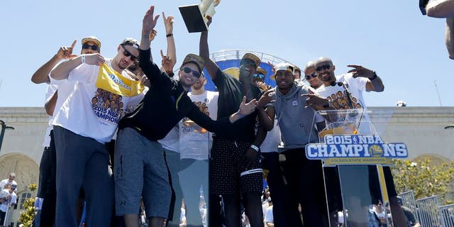 Golden State Warriors players celebrate after a parade and rally for winning the NBA championship in Oakland, Calif., Friday, June 19, 2015. (AP Photo/Jeff Chiu)