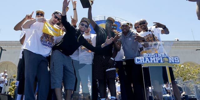 Golden State Warriors players celebrate after a parade and rally for winning the NBA championship in Oakland, Calif., Friday, June 19, 2015. (AP Photo/Jeff Chiu)