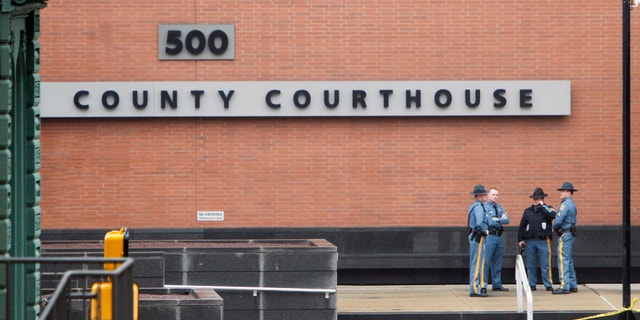 Law enforcement officials and investigators gather outside the New Castle County Courthouse in Wilmington, Del., in 2013.