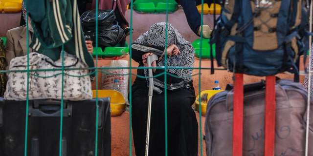 A Palestinian woman waits for a travel permit to cross into Egypt through the Rafah border crossing.