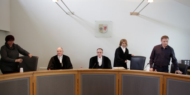 Klaus Kabisch, center, presiding judge at the trial against former SS medic Hubert Zafke arrives with the panel of judges.