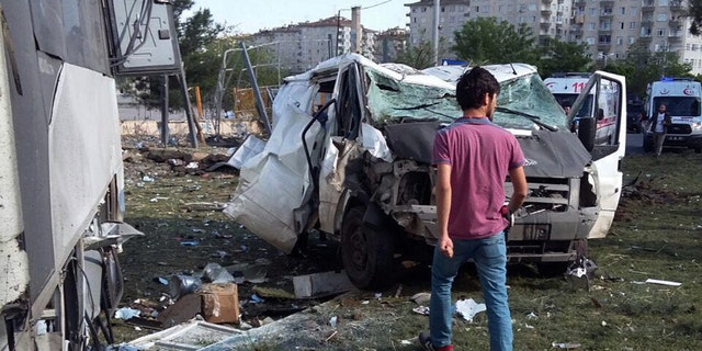 ALTERNATIVE CROP OF ANK102 - A security officer works at the explosion site after a car bomb struck a bus carrying Turkish police officers in the mainly-Kurdish city of Diyarbakir, Turkey, Tuesday, May 10, 2016, wounding at least 12 people, the state-run news agency reported. The Anadolu Agency said the attack in Diyarbakir's troubled Baglar neighborhood was carried out by the outlawed Kurdistan Workers' Party, or PKK, as the bus was passing by. (AP Photo)