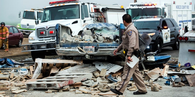 Emergency personnel work at the scene of a crash, one of several separate collisions, on Highway 59 in Merced County, Calif., Saturday, Feb. 13, 2016. The CHP says there was fog on the highway around the time of the crashes, but the cause remains under investigation. (Andrew Kuhn/Merced Sun-Star via AP)