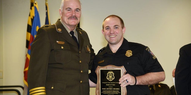 In this Feb. 22, 2017 photo provided by Montgomery County Police, Officer Jeff Hughes, right, poses for a photo with the Medal of Valor award with Chief Tom Manger in Gaithersburg, Md.