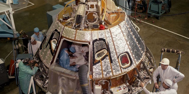 In this 1966 photo made available by NASA, technicians work on the Spacecraft 012 Command Module at Cape Kennedy, Fla., for the Apollo/Saturn 204 mission. During a launch pad test on Jan. 27, 1967, a flash fire erupted inside the capsule killing three Apollo crew members. (NASA via AP)