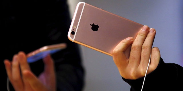 File photo - Customers hold the iPhone 6s during the official launch at the Apple store in central Sydney, Australia, September 25, 2015. (REUTERS/David Gray)
