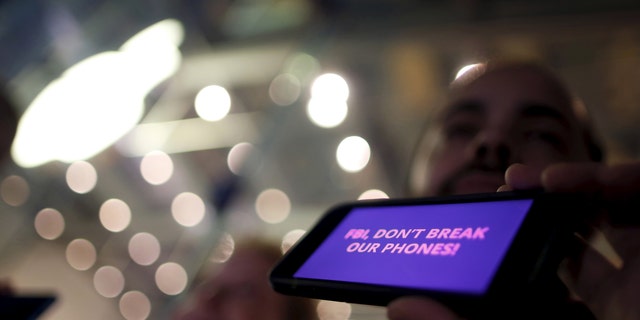 File photo - A man displays a protest message on his iPhone at a small rally in support of Apple's refusal to help the FBI access the cell phone of a gunman involved in the killings of 14 people in San Bernardino, in Santa Monica, California, United States, Feb. 23, 2016. (REUTERS/Lucy Nicholson)