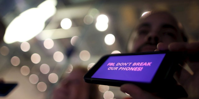 File photo - A man displays a protest message on his iPhone at a small rally in support of Apple's refusal to help the FBI access the cell phone of a gunman involved in the killings of 14 people in San Bernardino, in Santa Monica, California, United States, Feb. 23, 2016. (REUTERS/Lucy Nicholson)